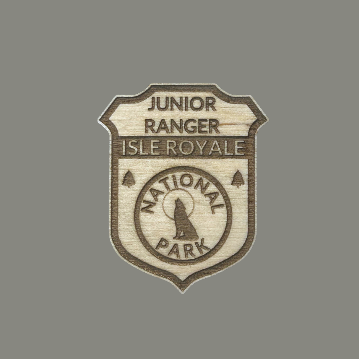 Wooden badge with 'Junior Ranger Isle Royale National Park' text on a gray background