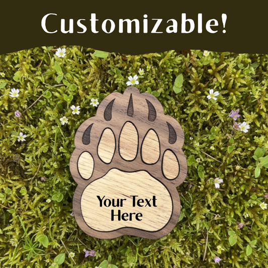 Wooden paw print decoration with customizable text on a green moss background