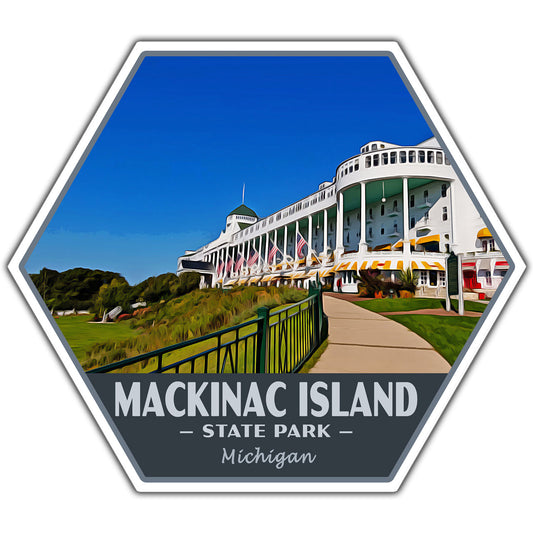 A hexagonal sticker featuring a scenic photograph of the Grand Hotel on Mackinac Island, Michigan, with the text 'MACKINAC ISLAND - STATE PARK - Michigan' on a dark gray banner at the bottom.