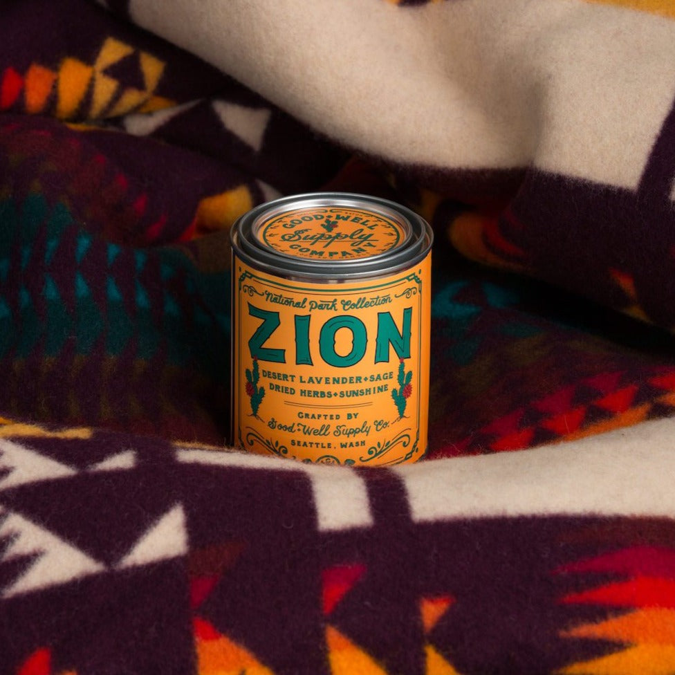 Zion canister candle on a patterned fabric background