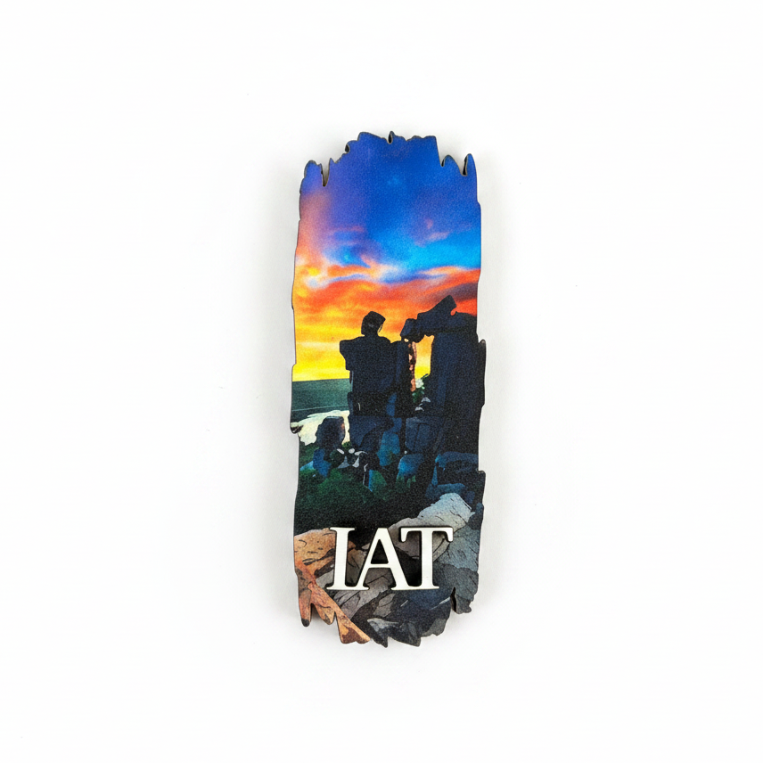A vertical rectangular magnet featuring a colorful sunset scene with silhouetted rock formations and the text 'IAT' in white at the bottom, shown on a plain white background.