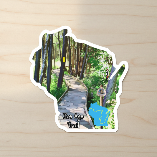 Sticker of Wisconsin with a trail scene and 'Ice Age Trail' text on a wooden surface