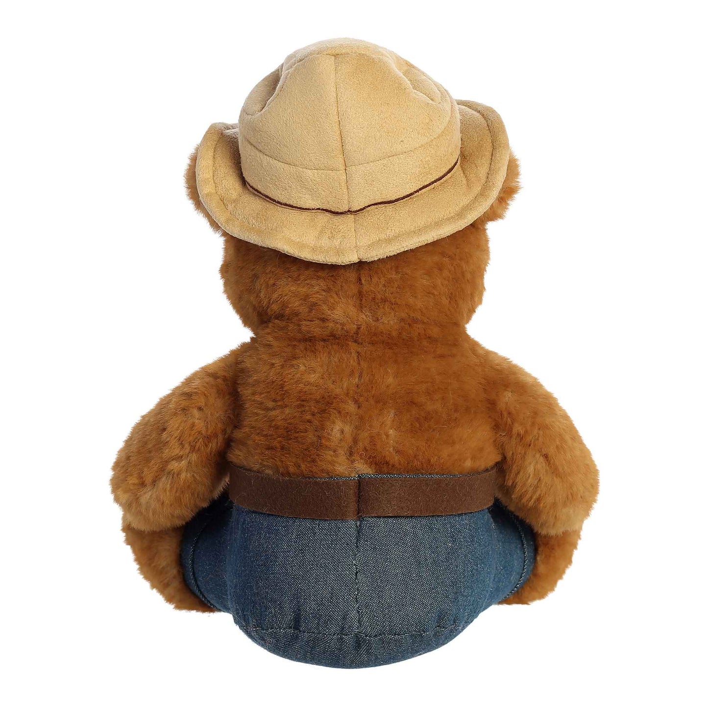 Brown teddy bear wearing a beige hat and blue pants on a white background