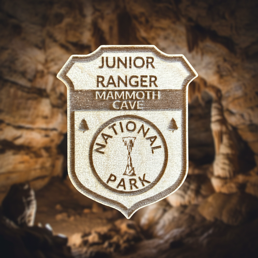 Junior Ranger badge from Mammoth Cave National Park against a cave background