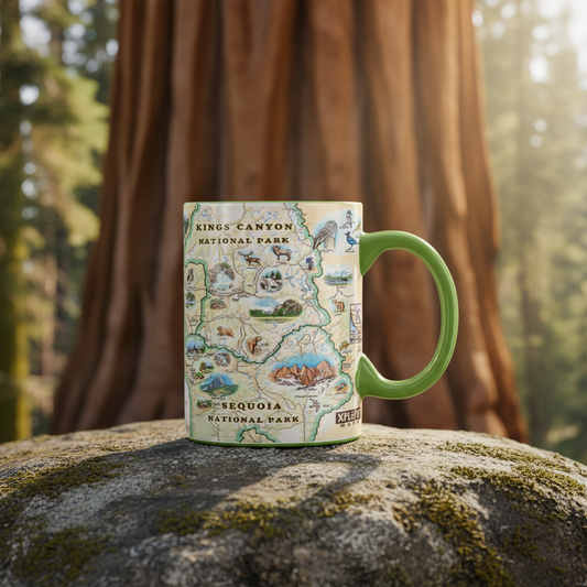 A ceramic mug featuring a vintage-style illustrated map of Kings Canyon and Sequoia National Parks, with a bright green handle, resting on a mossy rock in a forest setting.